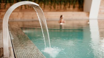 Pessoa na piscina interior aquecida do Lamego Hotel & Life Spa By L'Occitane