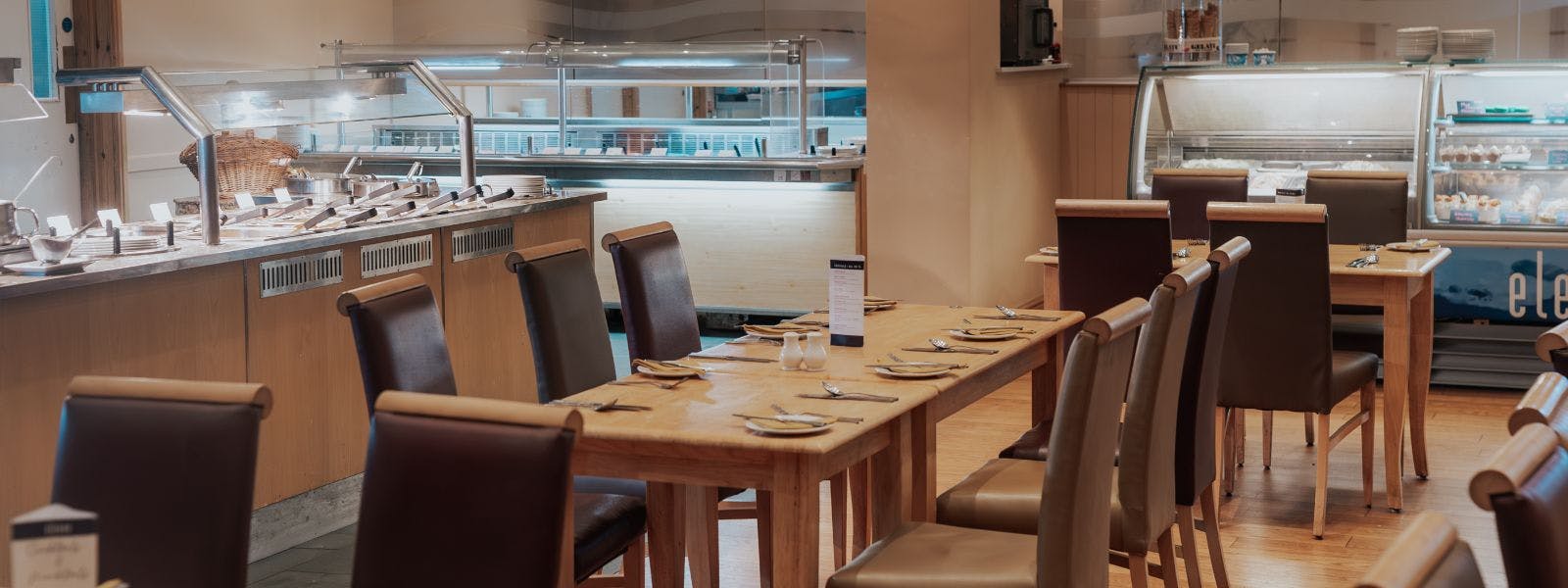 Spacious restaurant with carvery filled with numerous tables and chairs.