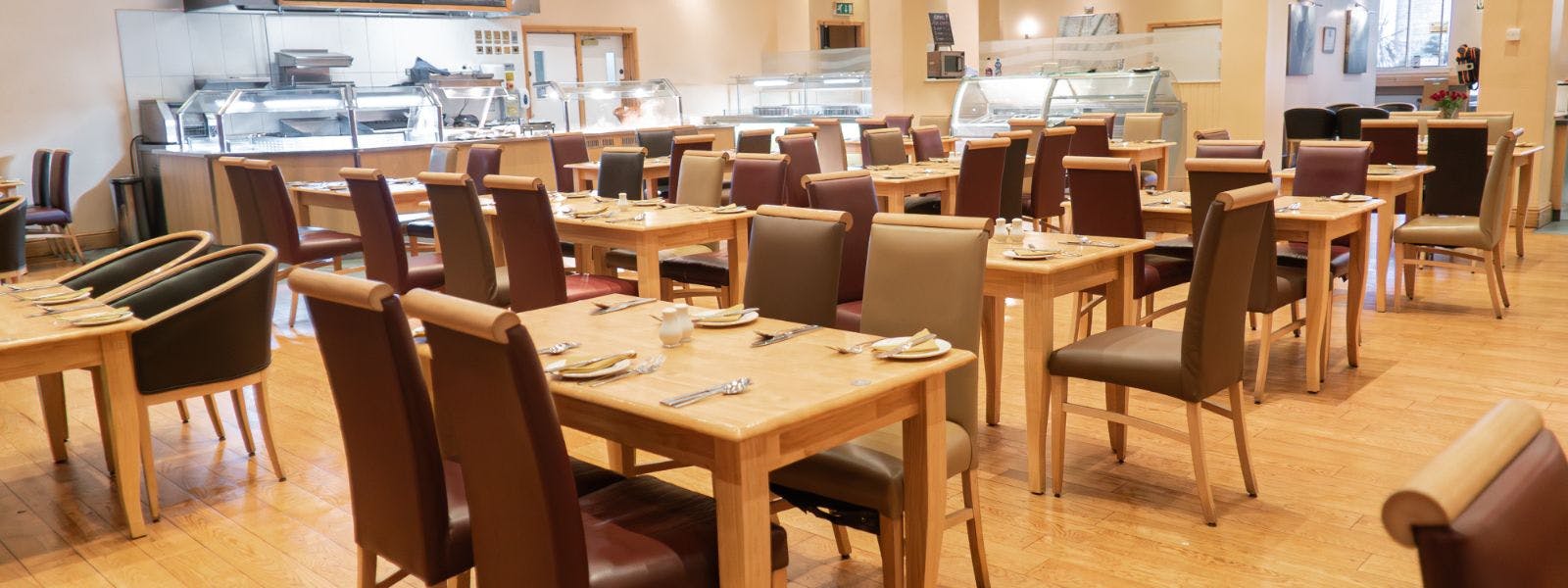 Spacious restaurant with carvery filled with numerous tables and chairs.