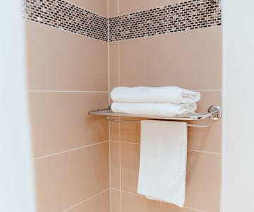 A bathroom towel rack with neatly folded towels ready for use after shower.
