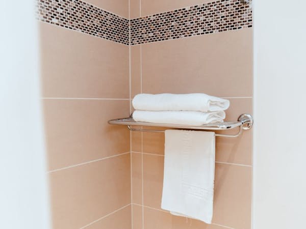 A bathroom towel rack with neatly folded towels ready for use after shower.