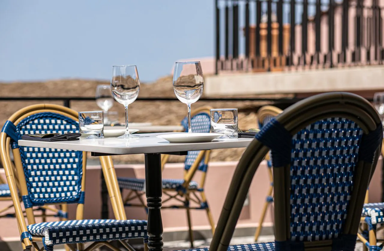 Outdoor dining table set with wine glasses at La Ola