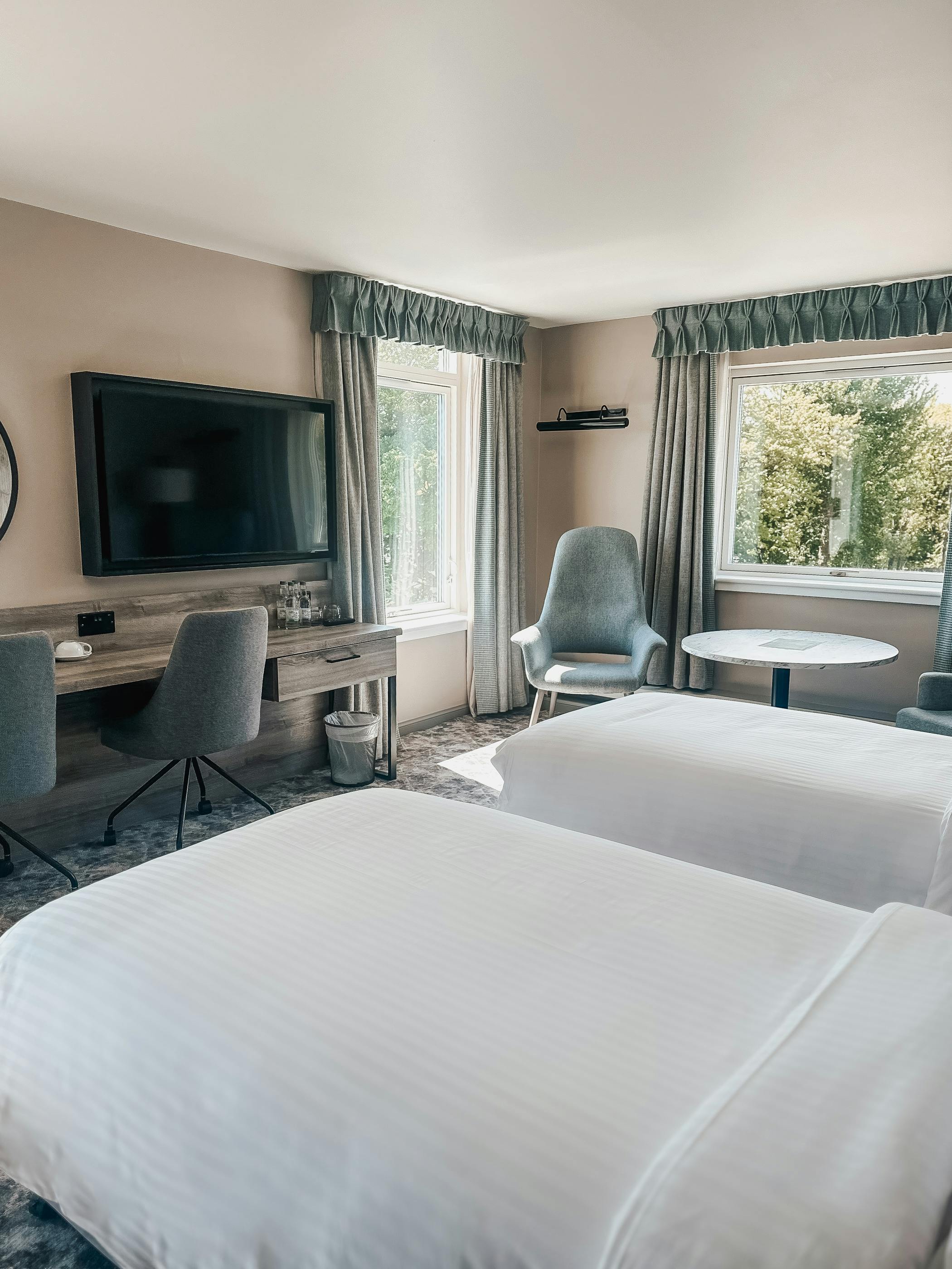 Executive twin room at Cabarfeidh Hotel featuring two beds and a large window with natural light.