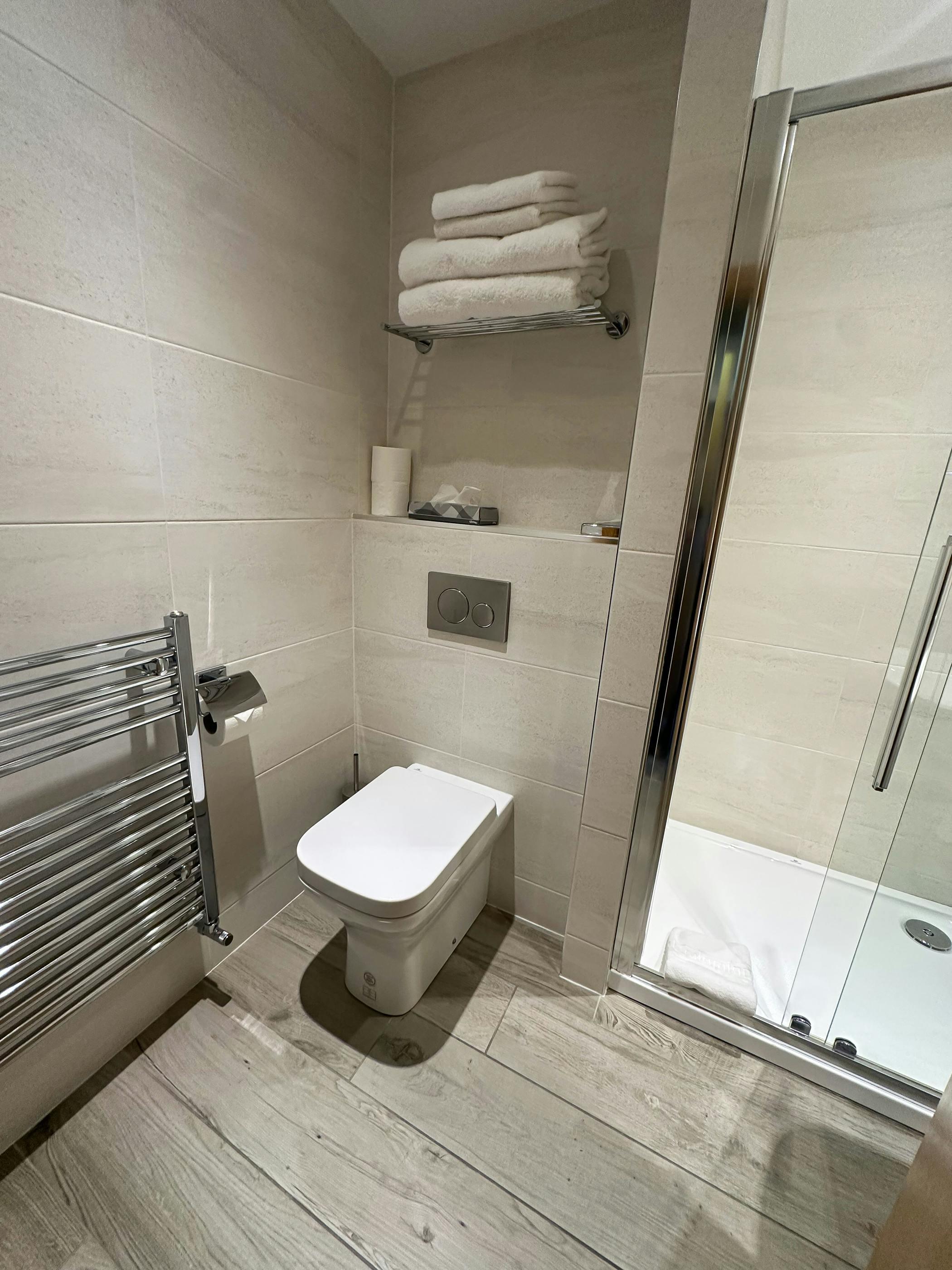 A well-appointed bathroom in Cabarfeidh Hotel with a shower, toilet, and sink for guest use.