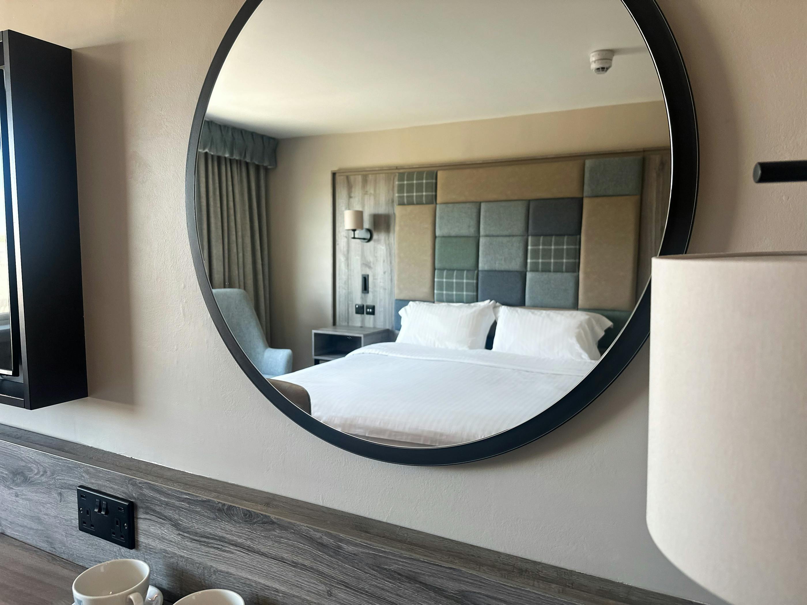 Executive double room at Cabarfeidh Hotel, with a large wall mounted mirror showing a large comfortable room.