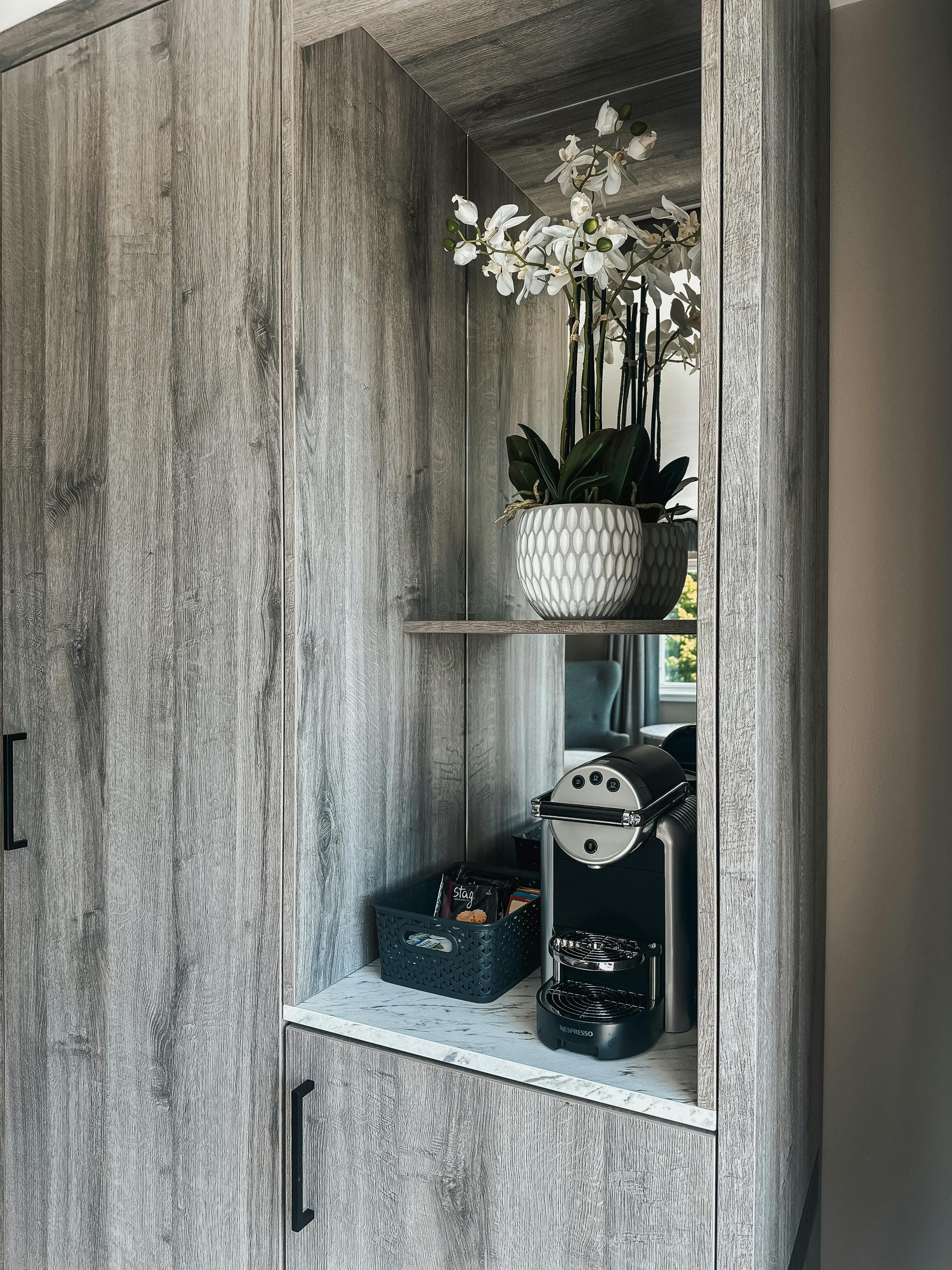 Shelf in the executive room at Cabarfeidh Hotel featuring a coffee maker and a green plant.