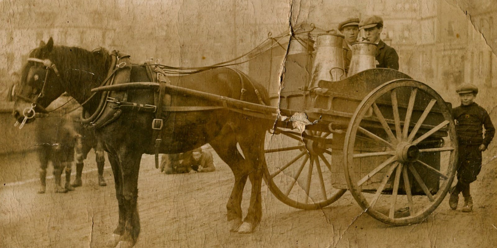 A horse-drawn carriage with two men seated, showcasing a charming rural scene.