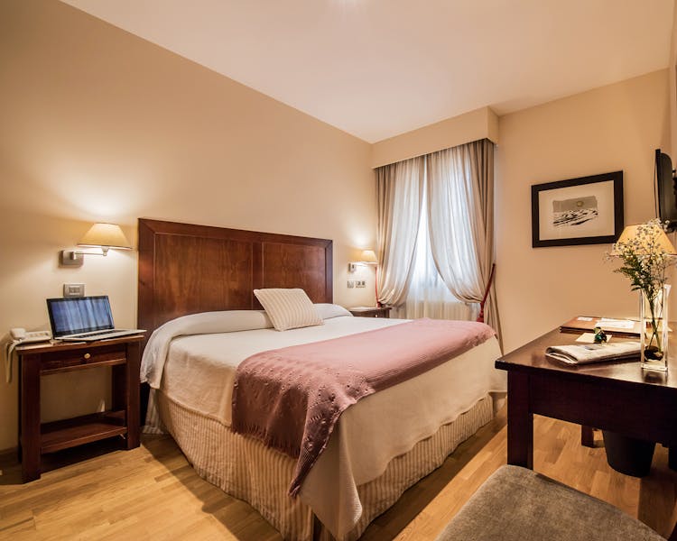 Habitación clásica con cama de matrimonio.