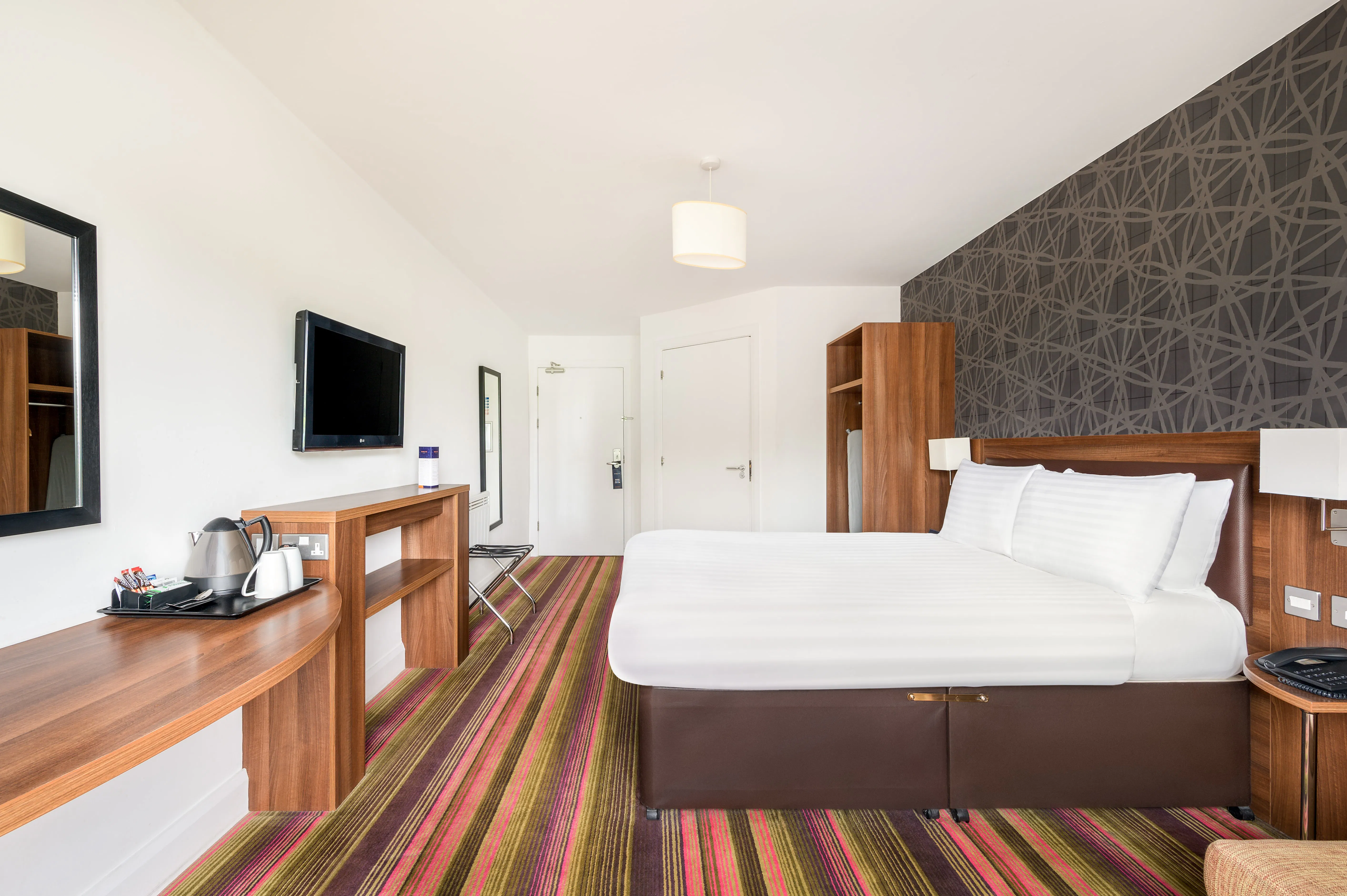 Rooms Inn Newcastle Superior Double room side view of bed, tv and amenities