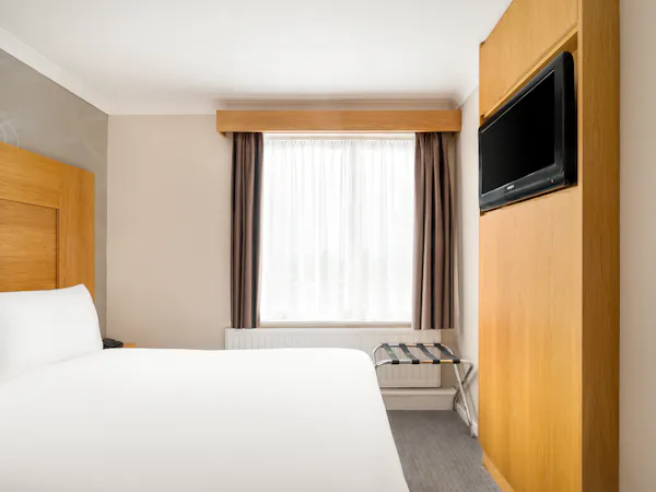 Rooms Inn Newcastle bed laid next to airy window