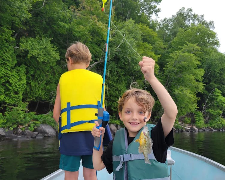 Kid-Friendly Fishing Cottages in Ontario - boy Holding a Fish at DaySpring Cottages