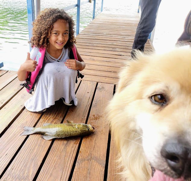 A girl, her dog, and a fish.