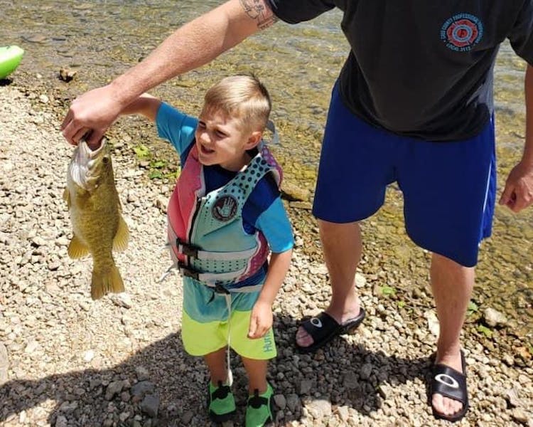boy fishing with dad holding small mouth bass table rock lake fishing