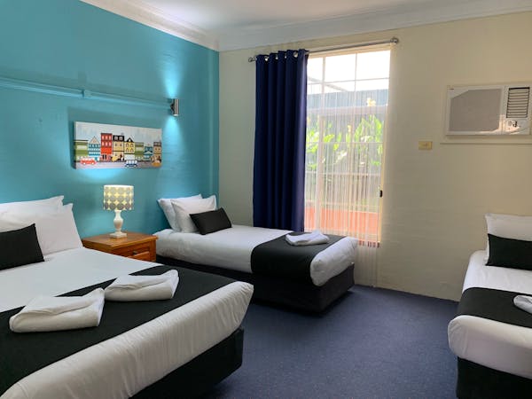 Family Suite Queen Bed & 2 Single Beds in back area of suite