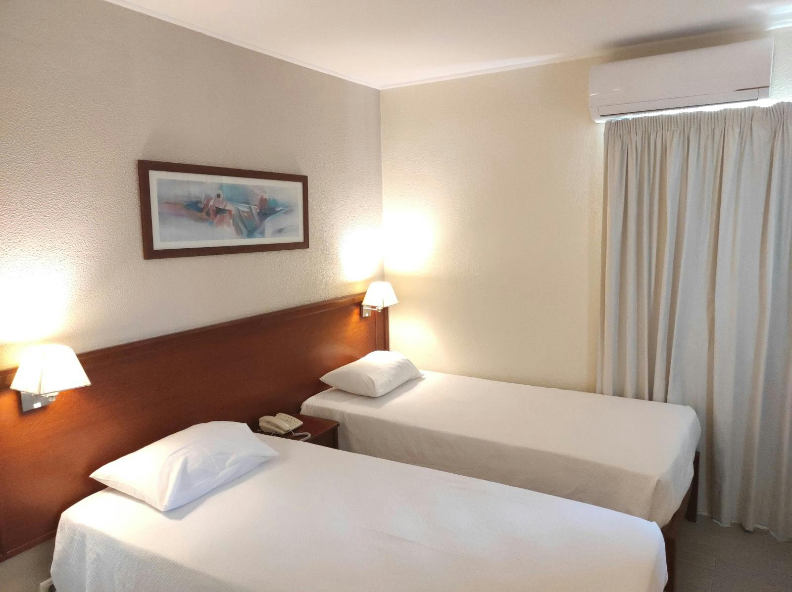 Comfortable Bed room With Estoril city view window Quarto confortável com vista para a cidade do Estoril