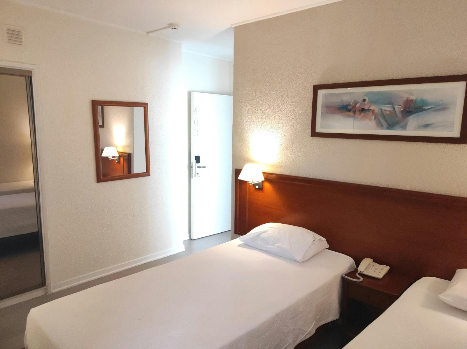 Comfortable Bed room With Estoril city view window Quarto confortável com vista para a cidade do Estoril