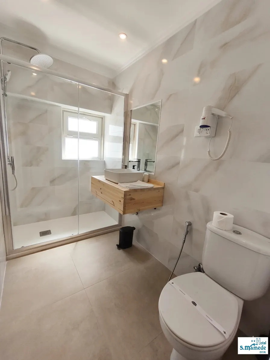 Modern ensuite bathroom with walk-in shower in renovated Estoril room