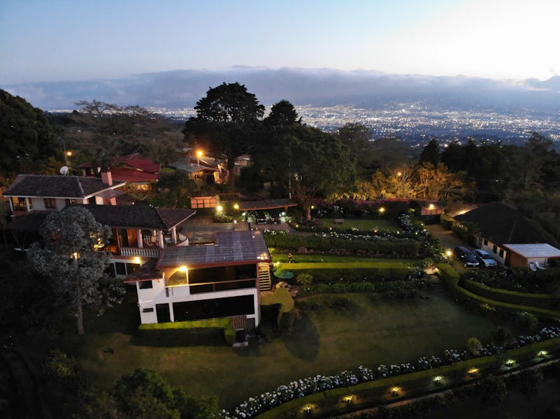 Finca Paraiso Mountain Retreat at dusk with San Jose in the background