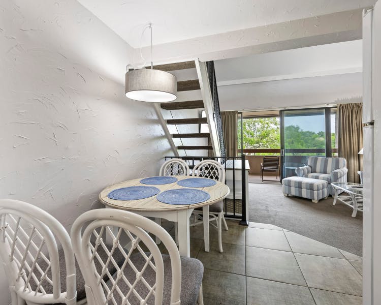 Dining area with beach-style decor and staircase at Sea Crest Surf & Racquet Club unit
