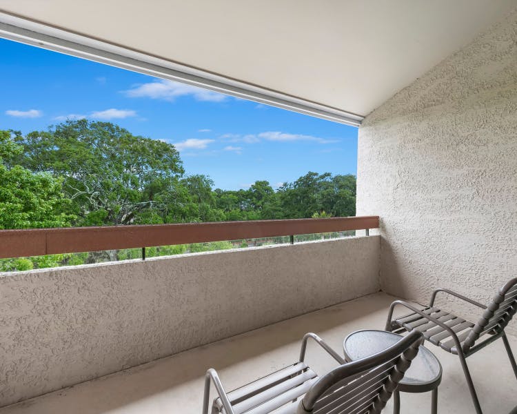 Balcony view overlooking lush greenery at Sea Crest Surf & Racquet Club Hilton Head