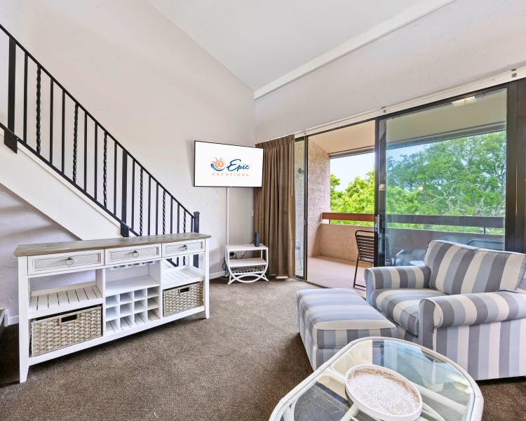 Cozy living area with staircase and TV at Sea Crest Surf & Racquet Club 1 Bedroom + Loft villa