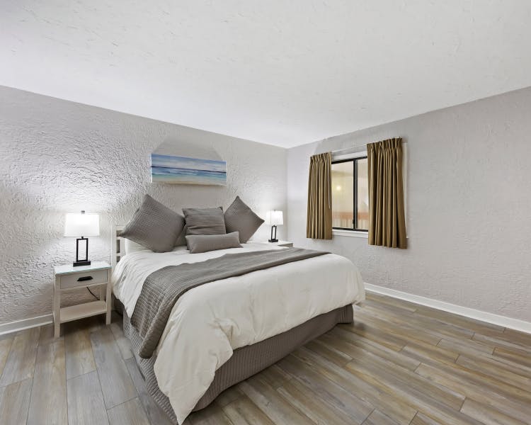 Primary bedroom with king bed and natural light at Sea Crest Surf & Racquet Club Hilton Head