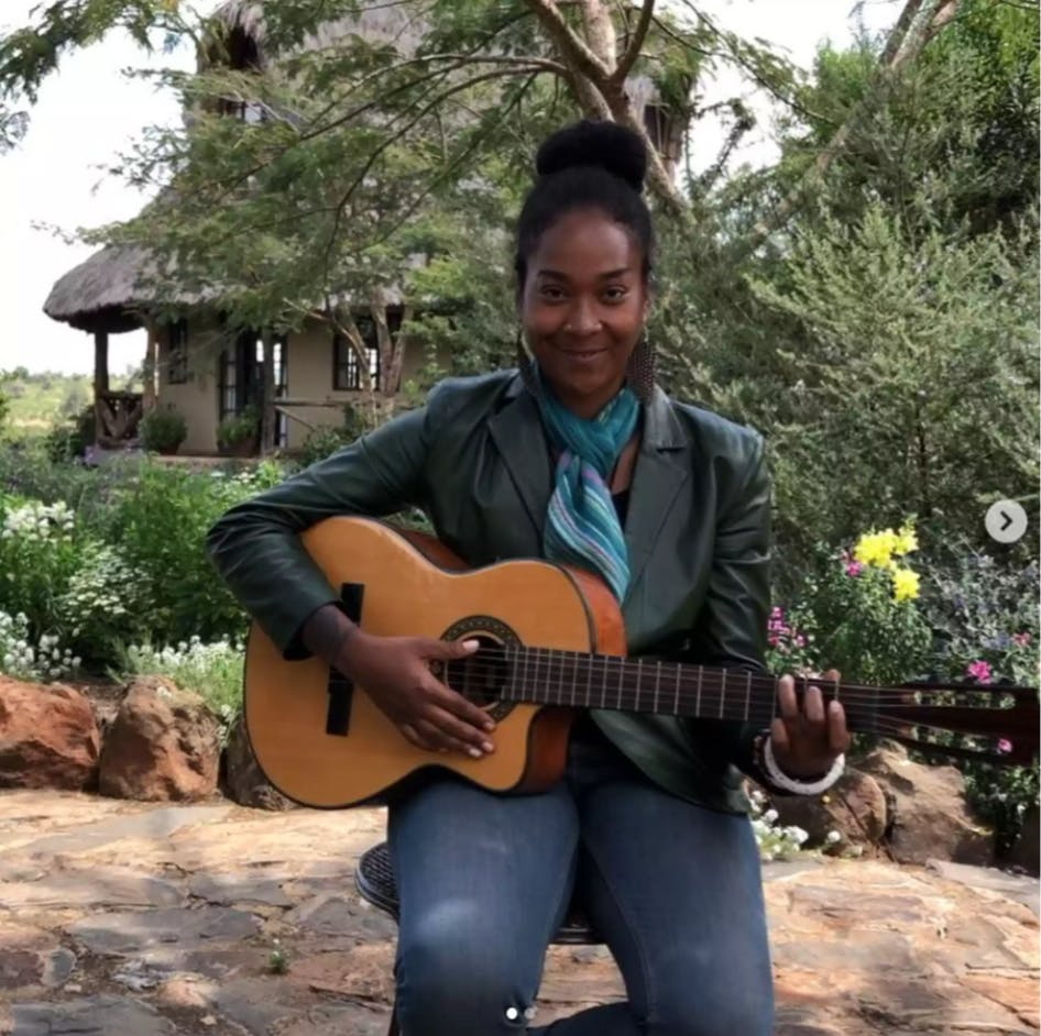 Artist Zizzy playing her guitar at Olepangi Farm