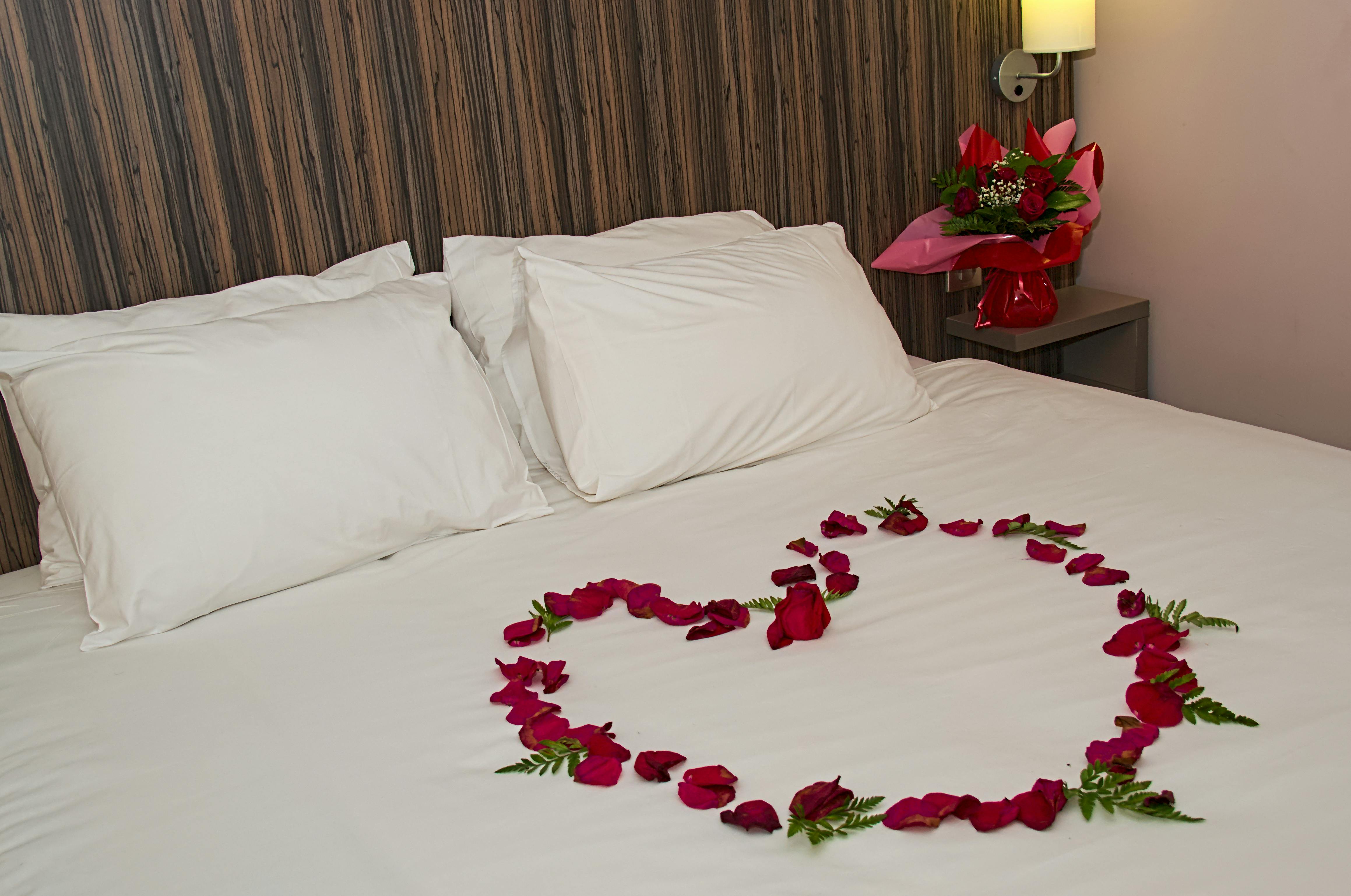 Pétales de roses en forme de coeur sur un lit à Eclipse, Rose petal heart on bed at Eclipse