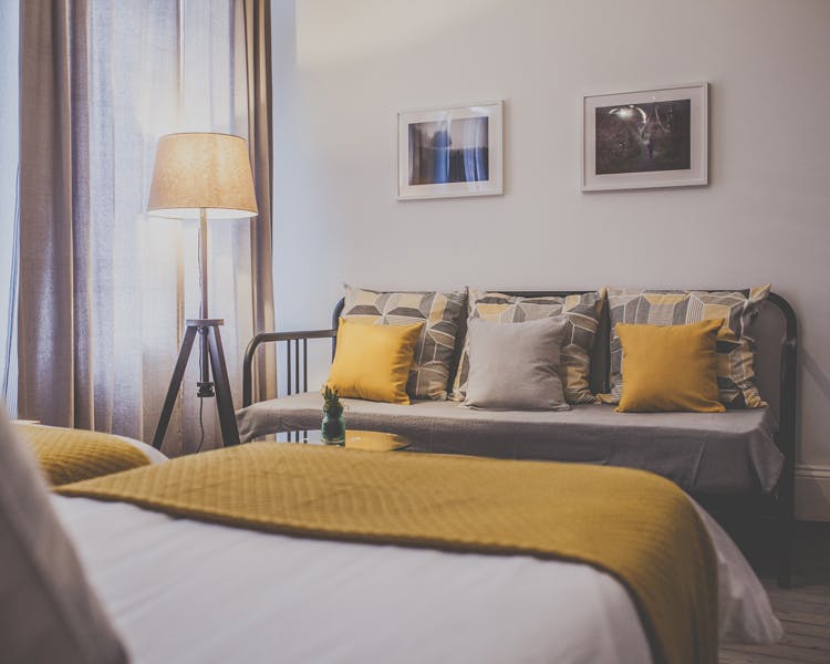 A stylish and unique decorated triple room with cozy lightning features and a sleeping couch