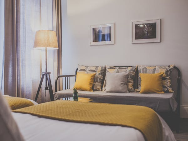 A stylish and unique decorated triple room with cozy lightning features and a sleeping couch