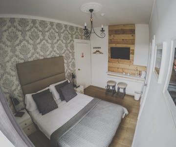 A beautifully decorated double room with ensuite in a cozy atmosphere. Two stools standing underneath the TV