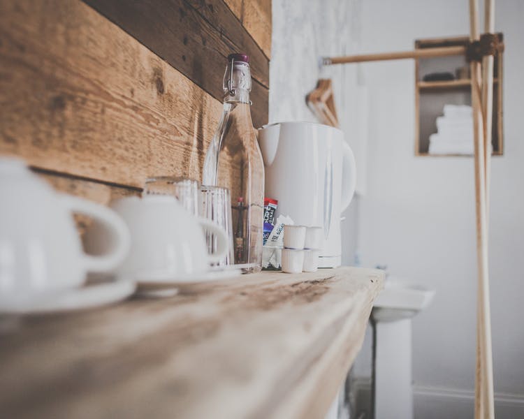 Coffee, tea and a bottle of water standing on a wooden shelve