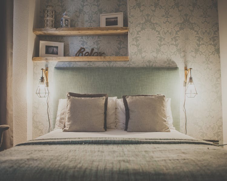 Pillows are on the bed of a beautifully decorated double room with ensuite, table lamps creating a cozy atmosphere