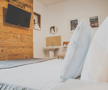 A double room decorated in a maritime style coming along with a TV, sink, hangers and shabby chic furniture