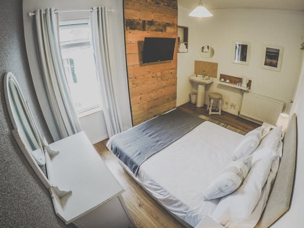 A double room decorated in a maritime style coming along with a TV, sink, hangers and shabby chic furniture