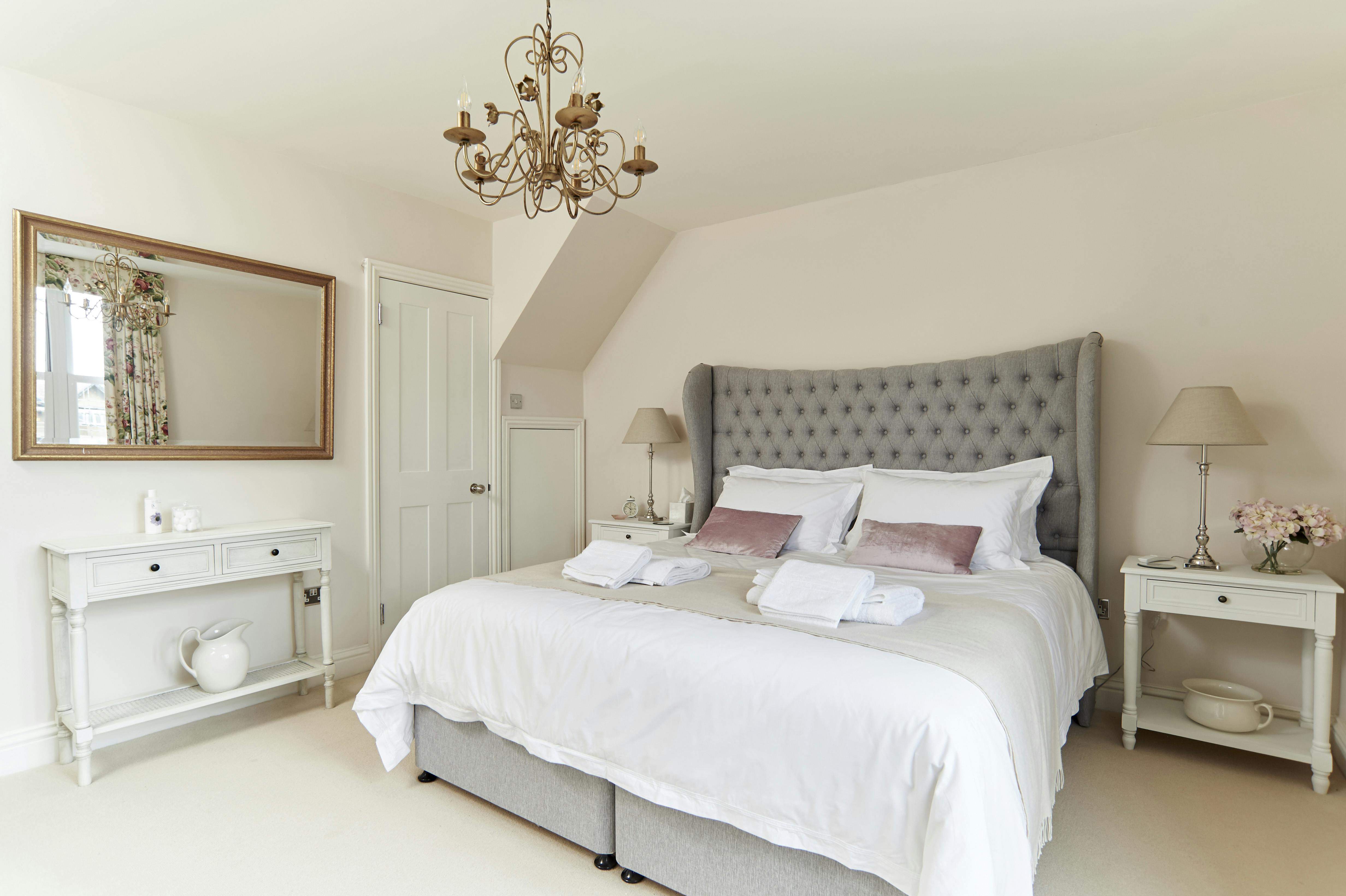 View of Master bedroom Hypnos Bed with beautiful, decorative headboard, crisp white bed linen and throw.