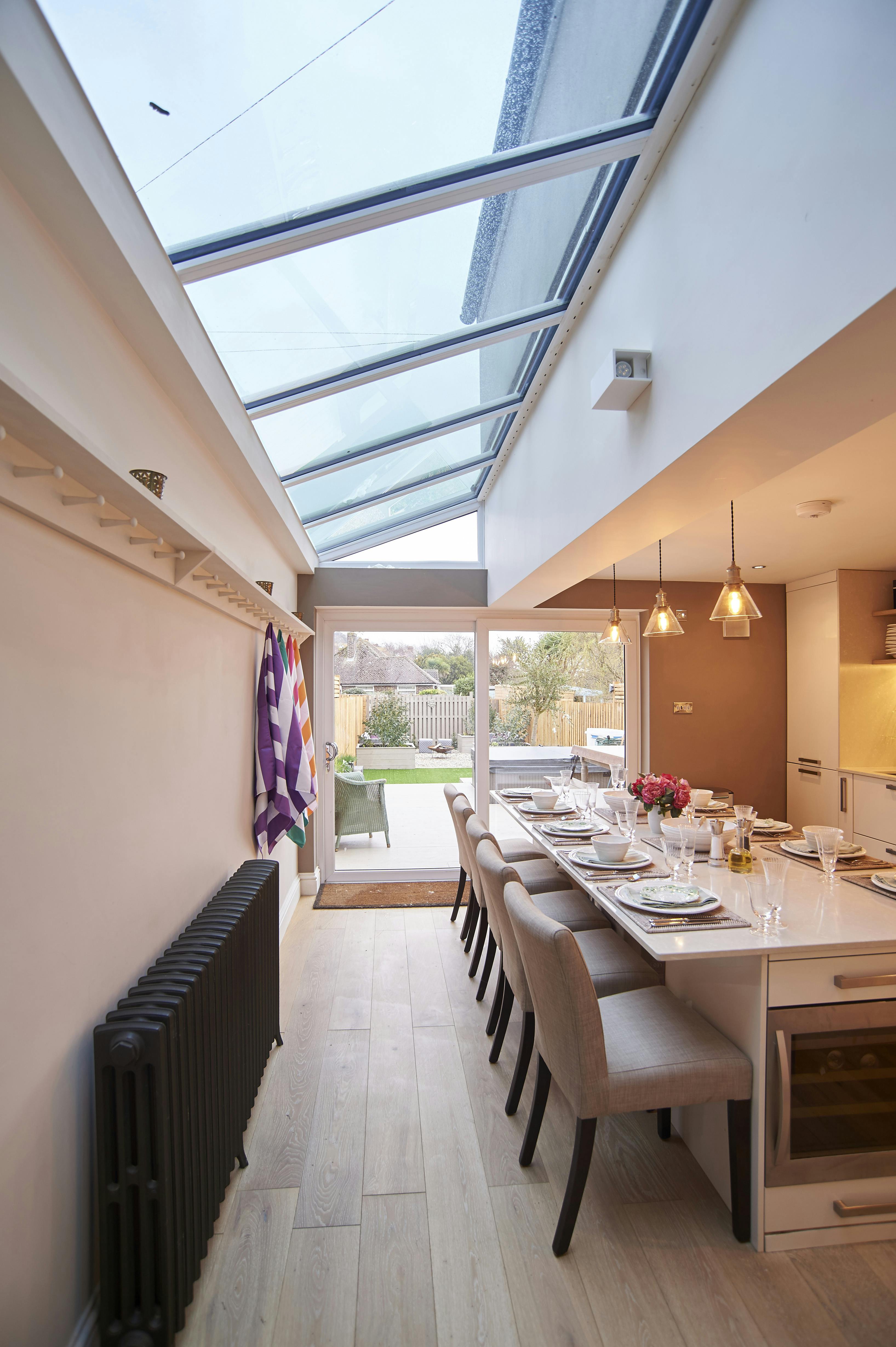 Kitchen view through to decking/terrace detailing 10 Seat dining table with 5 seats and long bench.