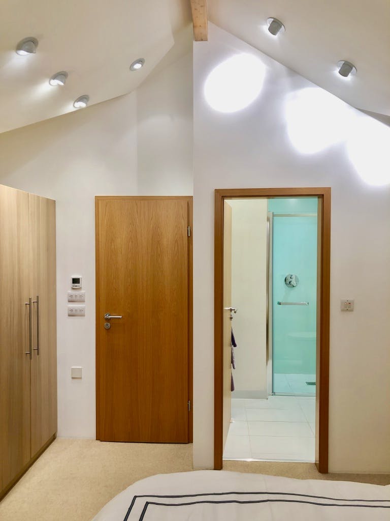 Bedroom 2 - picture of open en-suite door with vaulted ceiling and downlights