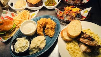 Several plates of southern cooked food including fried chicken