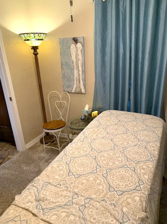 Massage table with blue and cream patterned blanket at Jamie's Massage & Hair Salon
