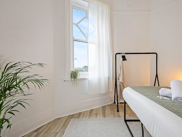 Large queen bed in deluxe double room with clothes rail, complimentary toiletries and towels.