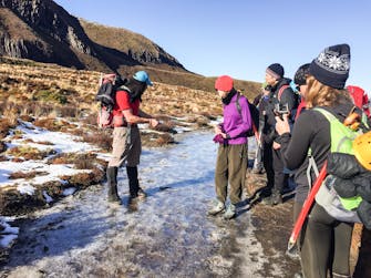 Guide talking to the group of people on Tongariro Alpine Crossing in winter