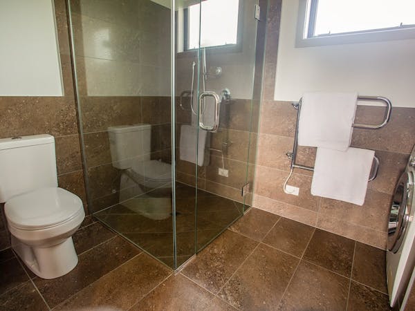 A rustic-modern bathroom with large shower at Musterer's Accommodation, Fairlie.
