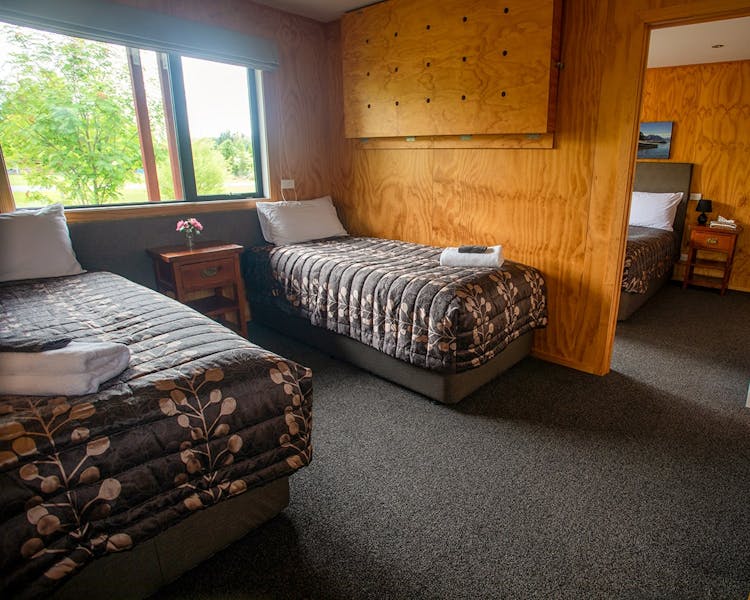 A timber bedroom with two beds at Musterer's Accommodation, Fairlie.