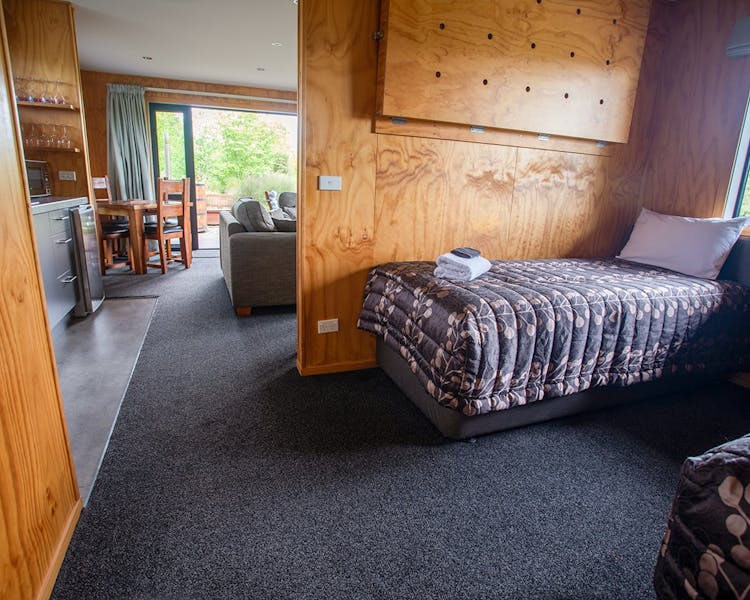 A modern-rustic living area with a bedroom nook at Musterer's Accommodation, Fairlie.