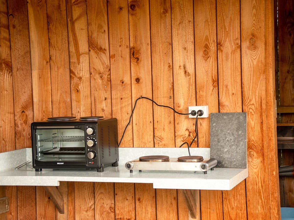 A kitchenette bench with rustic timber wall at Musterer's Accommodation, Fairlie.