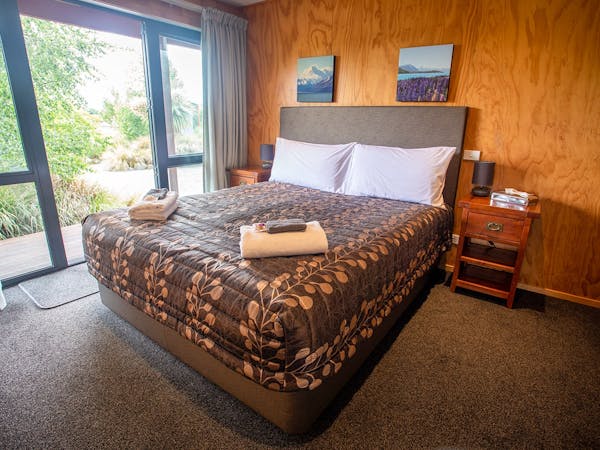 A timber room with a large bed at Musterer's Accommodation, Fairlie.
