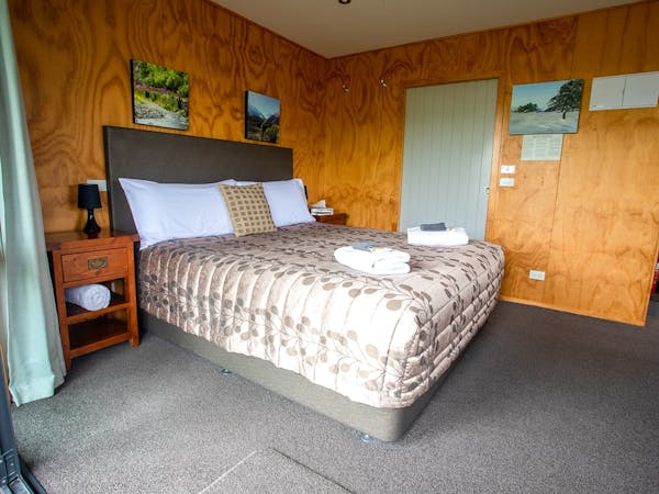 A large bed in a rustic room at Musterer's Accommodation, Fairlie.