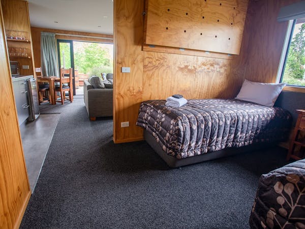 A modern-rustic living area with a bedroom nook at Musterer's Accommodation, Fairlie.