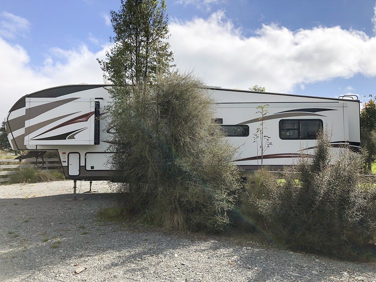 Large campervan parking area with native trees and shrubs at Musterer's Accommodation, Fairlie.